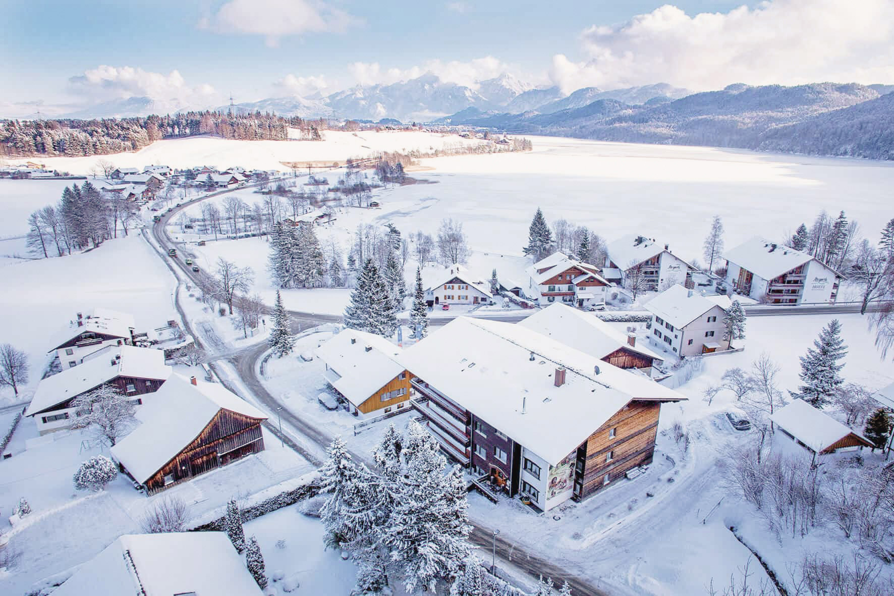 Luftbild im Winter vom Hotel Steigmühle im Allgäu mit Schnee und gefrorenem See