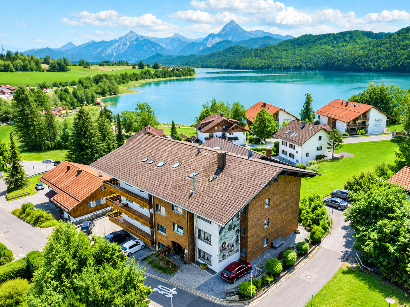 Hotel Steigmühle am Weissensee mit Blick über den See auf die Alpen